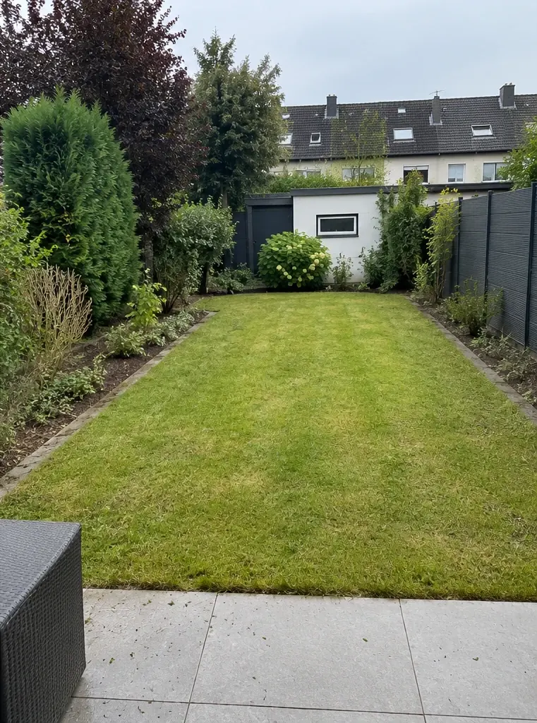 Nachher: derselbe Garten mit kurz gemähtem Rasen und klaren Beetkanten